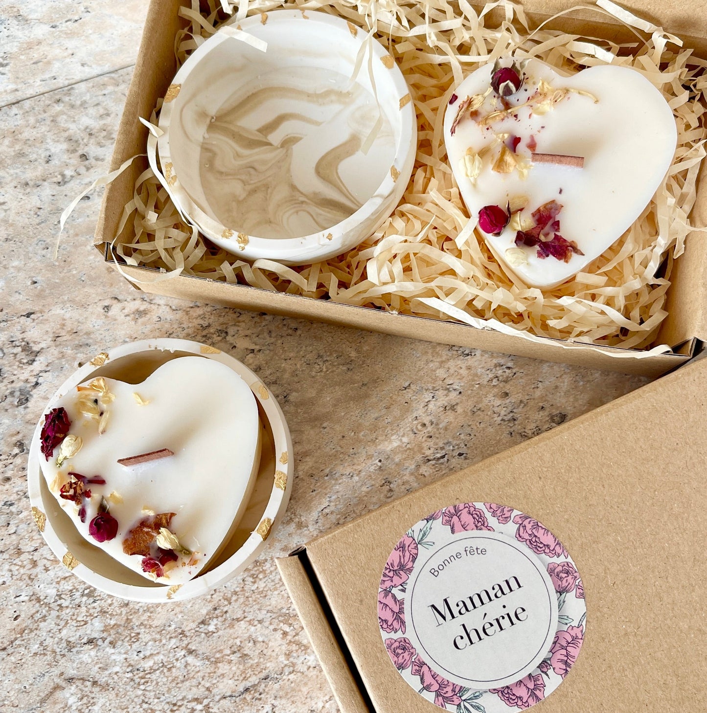 Coffret cadeau «  bonne fete Maman cherie » on vois une bougie en forme de cœur dévoré avec des fleurs séchées et une coupelle marbré et doré
